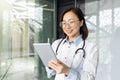 Professional asian female doctor consulting patients remotely with digital tablet Royalty Free Stock Photo