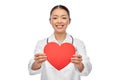 smiling asian female doctor holding red heart Royalty Free Stock Photo