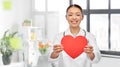 smiling asian female doctor holding red heart Royalty Free Stock Photo