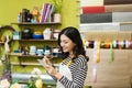 Smiling asian female florist making notes at flower shop counter Royalty Free Stock Photo