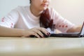 Smiling Asian female freelancer sitting and read a document online correspond with client in chat on her laptop