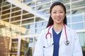 Smiling Asian female healthcare worker outdoors in lab coat Royalty Free Stock Photo