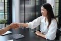 Smiling Asian female recruitment manager shaking hands with a job applicant after interview. Royalty Free Stock Photo