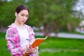 Smiling Asian Female Student with Folders and backpack in green summer park. education, campus and teenage concept Royalty Free Stock Photo