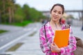 Smiling Asian Female Student with Folders and backpack in green summer park. education, campus and teenage concept Royalty Free Stock Photo