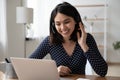Smiling Asian girl in headset watch webinar on laptop Royalty Free Stock Photo