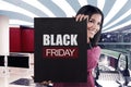 Smiling asian girl holding black banner sale with BLACK FRIDAY m