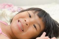 Smiling Asian girl lay down on bed Royalty Free Stock Photo
