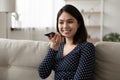 Smiling Asian girl record voice message on smartphone Royalty Free Stock Photo