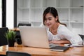 Smiling asian girl student using laptop computer study online with teacher, happy young woman learn language listen Royalty Free Stock Photo