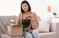 Smiling asian lady unpacking parcel with beauty box Royalty Free Stock Photo