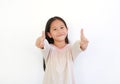 Smiling Asian little child girl child pointing at you and looking camera isolated on blue background. Kid point two index fingers Royalty Free Stock Photo