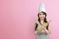 Smiling asian little girl in chef hat holding wooden cooking ute Royalty Free Stock Photo