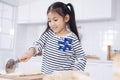 Smiling Asian little asian girl child is learning and enjoying for baking cookies bakery on wooden Cutting board in kitchen. Royalty Free Stock Photo