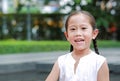 Smiling Asian little girl eating bread with Stuffed Strawberry-filled dessert and Stained around her mouth in garden outdoor Royalty Free Stock Photo