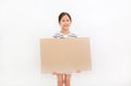 Smiling asian little girl holding empty brown big board for media banner isolated on white background with copy space Royalty Free Stock Photo