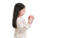 Smiling asian little girl holding red apple in hands and looking it over white background. Side view Royalty Free Stock Photo