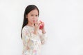 Smiling asian little girl holding red apple in hands over white background Royalty Free Stock Photo