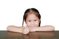Smiling asian little girl lying on wood table with looking camera isolated on white background Royalty Free Stock Photo