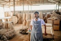 smiling Asian male entrepreneur standing in a woodcraft warehouse