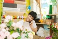 Smiling asian male florist calling on smartphone and making note Royalty Free Stock Photo