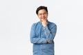 Smiling asian male student, freelancer in blue shirt and glasses listening with interest, nod while having conversation Royalty Free Stock Photo