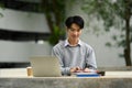 Smiling asian male student reading books, preparing for exam on table at campus. Youth lifestyle and education concept Royalty Free Stock Photo