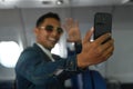 Smiling asian male travel blogger using smart phone recording his video vlog. Focusing on hand Royalty Free Stock Photo