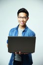 Smiling asian man standing with laptop Royalty Free Stock Photo