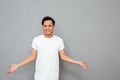 Smiling asian man standing over grey wall. Royalty Free Stock Photo