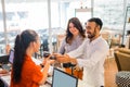 smiling Asian man using EDC device while buying and making payment