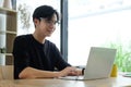 Smiling asian man working with laptop computer at home office Royalty Free Stock Photo