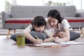 Smiling Asian mother and little asian girl child is drawing and Painting with wooden colored pencils on paper for imagination Royalty Free Stock Photo