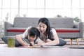 Smiling Asian mother and little asian girl child is drawing and Painting with wooden colored pencils on paper for imagination Royalty Free Stock Photo