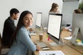 Smiling asian office employee looking at camera working with col Royalty Free Stock Photo