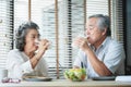 Smiling Asian senior man and woman drinking glasses of milk at home Royalty Free Stock Photo