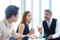 Smiling Asian team and Senior Caucasian boss is businesspeople teamwork relaxing and brainstorm. Businesswoman holding coffee Royalty Free Stock Photo