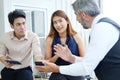 Smiling Asian team and Senior Caucasian boss is businesspeople teamwork relaxing and brainstorm. Businesswoman holding coffee Royalty Free Stock Photo