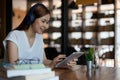 Smiling asian teenage wearing headset looking at tablet listen and learning online courses. Happy chinese business woman Royalty Free Stock Photo