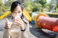 Smiling asian teenager girl drinking a glass of milk,enjoying and showing her thumb up,healthy woman drink fresh milk,confident Royalty Free Stock Photo