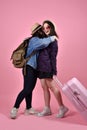 Smiling asian traveler girls hugging each other at airport.