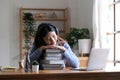 Smiling asian undergraduate teen girl student study in library with laptop books doing online research for coursework Royalty Free Stock Photo