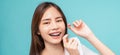 Smiling Asian woman cleaning braces on teeth with dental floss on blue background, Concept oral hygiene and health care Royalty Free Stock Photo