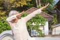 Smiling asian woman dabbing at the street in Thailand. Outdoors, summer, modern lifestyle concept