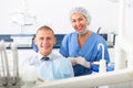 Dentist and happy patient sitting in dental chair