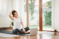 Asian woman doing yoga neck stretching online class at home