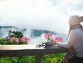 Smiling asian Woman drinking coffee and tea and take a photo and relax in sun sitting outdoor in sunshine light enjoy relax her wa Royalty Free Stock Photo