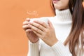 Smiling asian woman hand holding white cup of coffee at the winter weather relax time,