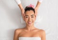 Smiling asian woman having face massage, relaxing in spa salon, top view Royalty Free Stock Photo