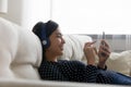 Smiling asian woman in headphones using smartphone at home Royalty Free Stock Photo